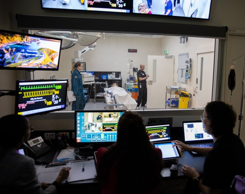 Medical clinicians watching through a window as doctors before a test surgery